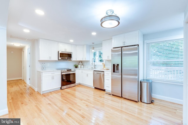 12452 White Horse Rd, Lusby, MD 20657 - kitchen featuring light wood finished floors, a sink, stainless steel appliances, light countertops, and white cabinetry