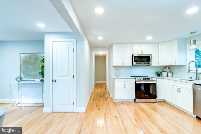 12452 White Horse Rd, Lusby, MD 20657 - kitchen with a sink, white cabinetry, light wood finished floors, and stainless steel appliances
