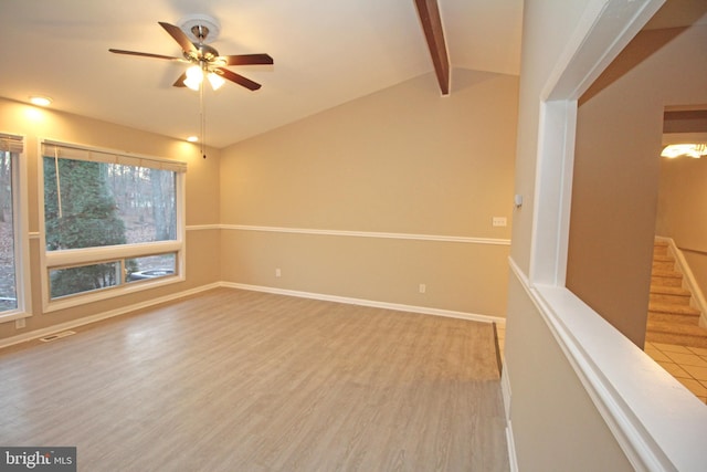 empty room with lofted ceiling with beams, hardwood / wood-style floors, and ceiling fan