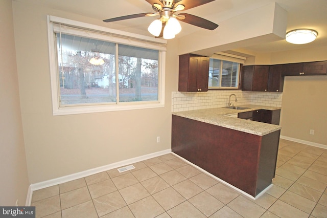 kitchen with tasteful backsplash, sink, dark brown cabinets, and light tile patterned flooring