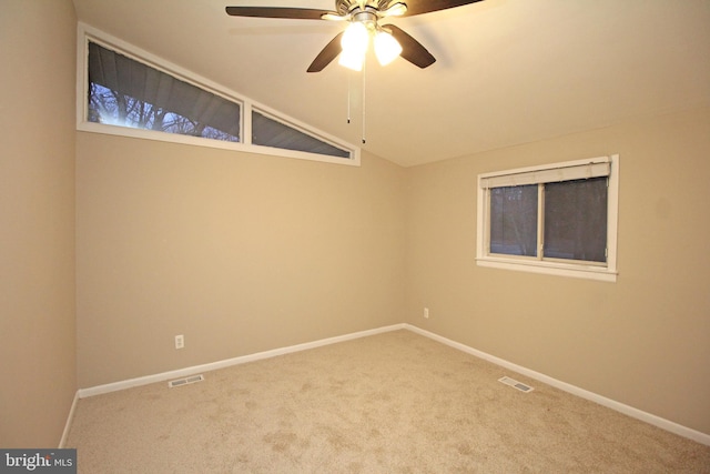 spare room with ceiling fan, lofted ceiling, and carpet floors