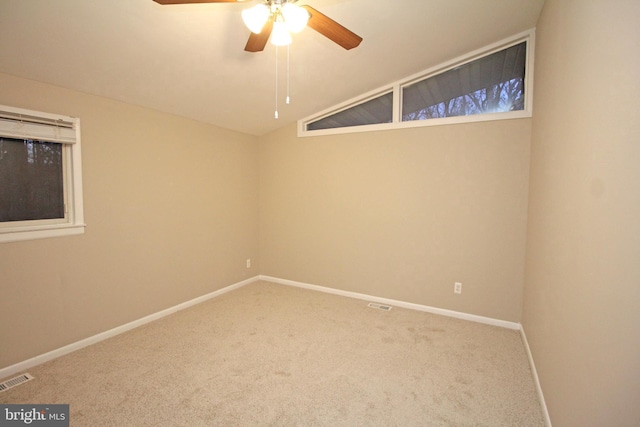 carpeted spare room with vaulted ceiling and ceiling fan