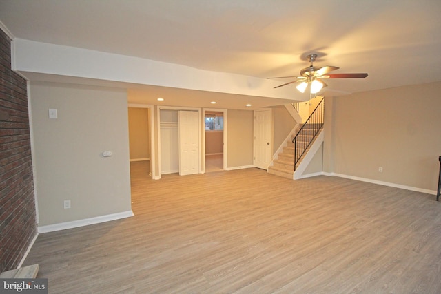 interior space with brick wall, hardwood / wood-style floors, and ceiling fan