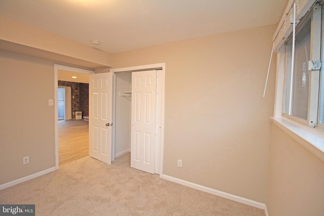 unfurnished bedroom with a closet and light carpet