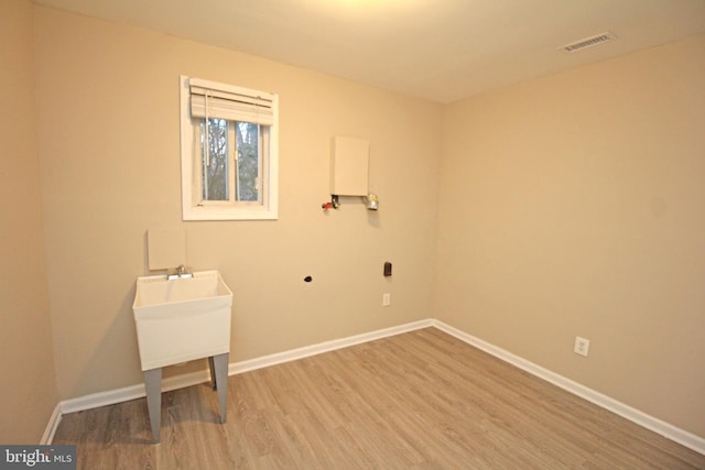 washroom with electric dryer hookup and light wood-type flooring