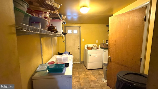 clothes washing area featuring light tile patterned floors and washer and dryer