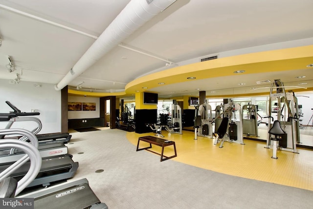 gym with carpet floors and track lighting