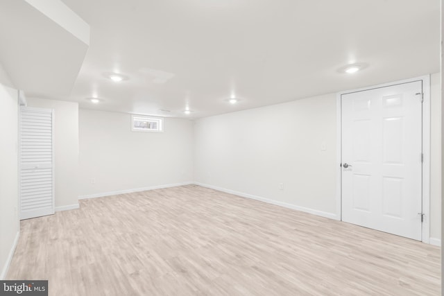 finished basement featuring baseboards and light wood-style flooring