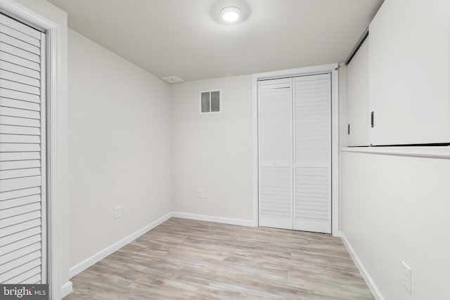 unfurnished bedroom with visible vents, baseboards, light wood-style floors, and a closet