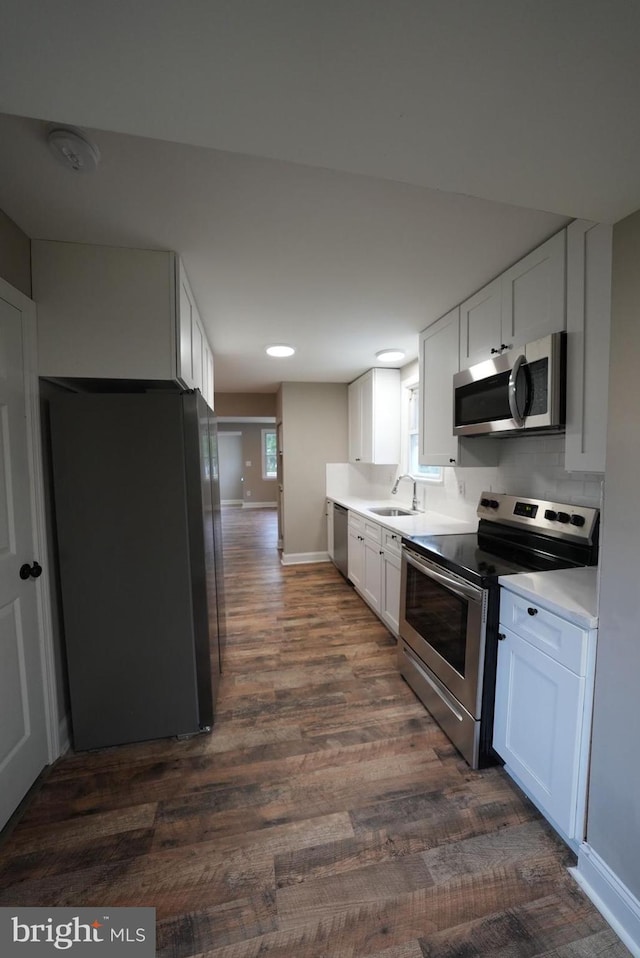 kitchen with white cabinetry, appliances with stainless steel finishes, dark wood-type flooring, and sink