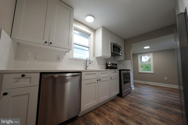 kitchen featuring dark wood-type flooring, white cabinetry, plenty of natural light, stainless steel appliances, and tasteful backsplash