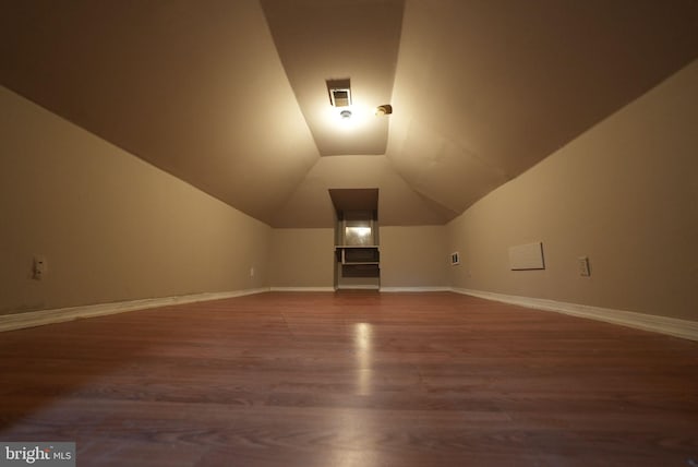 bonus room featuring dark wood-type flooring and lofted ceiling