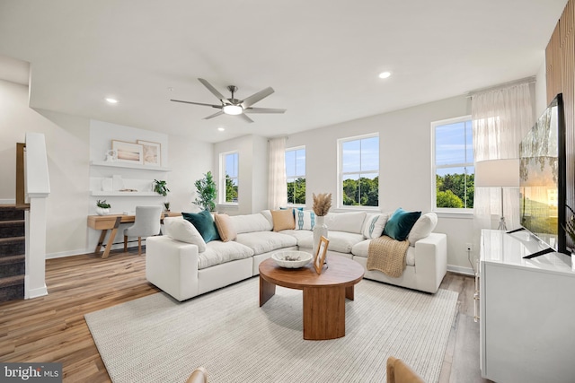 living room featuring ceiling fan, a healthy amount of sunlight, and light wood-type flooring