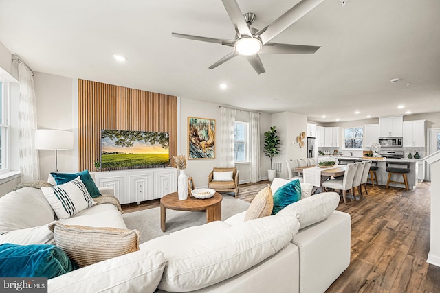 living room featuring ceiling fan, a healthy amount of sunlight, and dark hardwood / wood-style floors