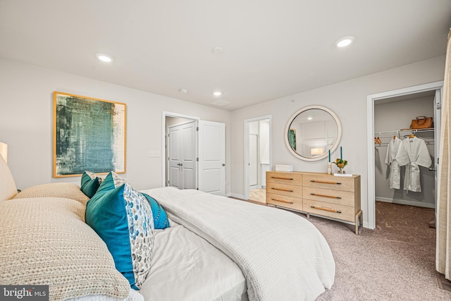 carpeted bedroom featuring a spacious closet and a closet