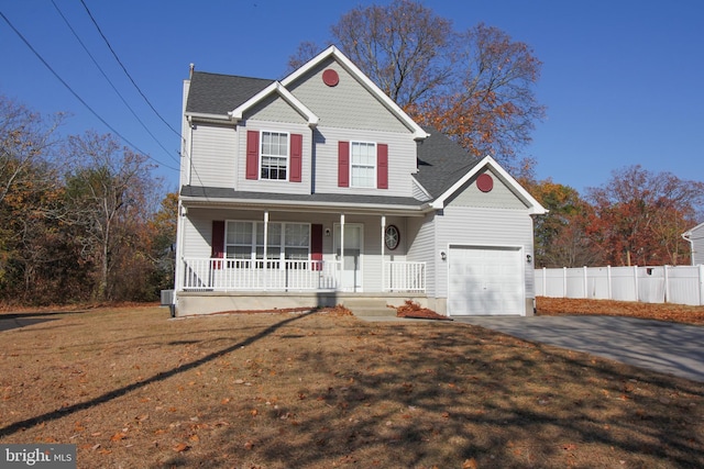 view of property with a garage, covered porch, and a front lawn