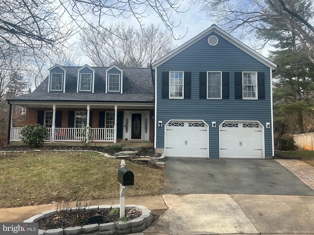 view of front of house featuring a porch, a garage, and a front lawn