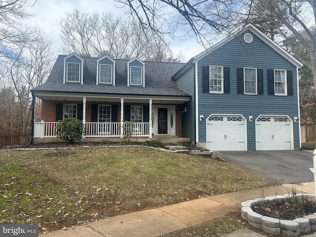 view of front of property featuring a garage, a porch, and a front lawn