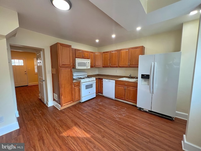 kitchen with sink, white appliances, and dark wood-type flooring