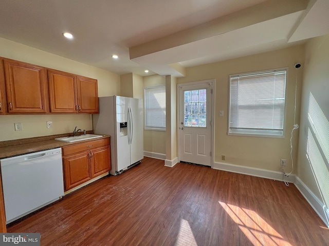 kitchen with hardwood / wood-style flooring, sink, and white appliances