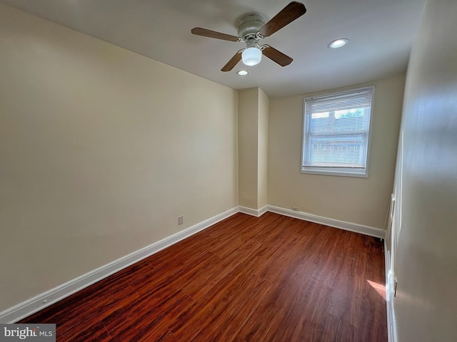 empty room with ceiling fan and dark hardwood / wood-style flooring