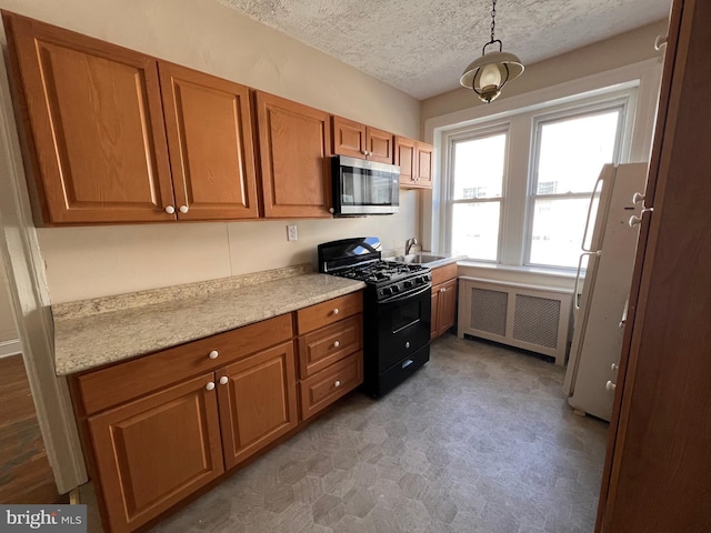 kitchen featuring black range with gas cooktop, sink, a textured ceiling, white refrigerator, and radiator