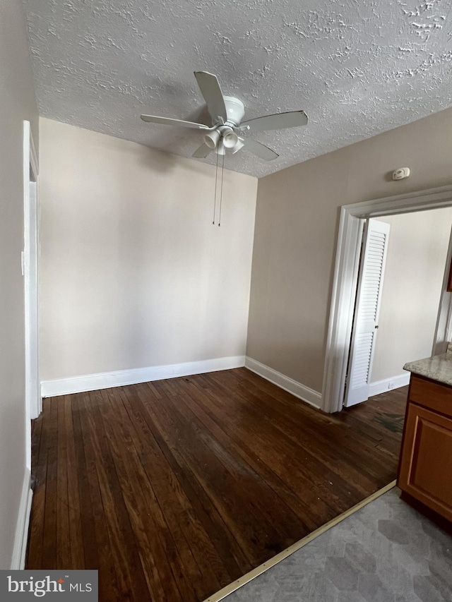 empty room featuring hardwood / wood-style flooring, a textured ceiling, and ceiling fan