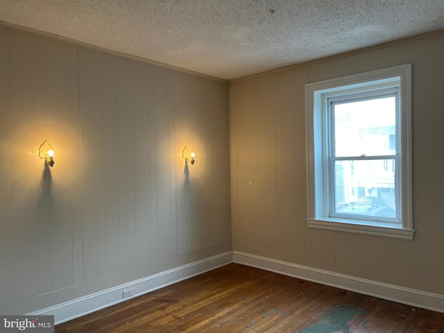 unfurnished room with dark hardwood / wood-style flooring and a textured ceiling