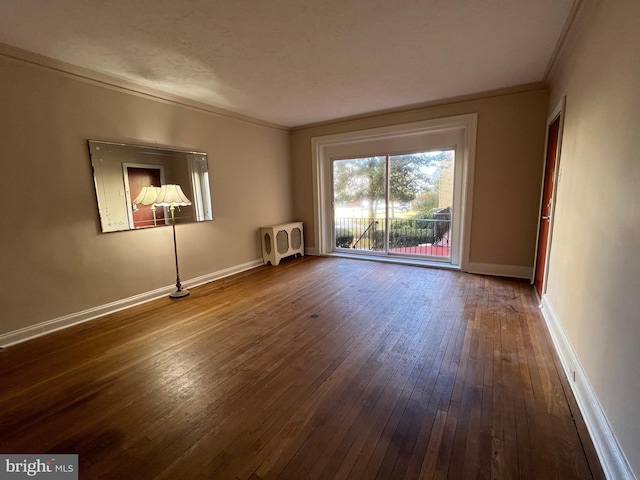 empty room with hardwood / wood-style flooring, crown molding, heating unit, and a textured ceiling