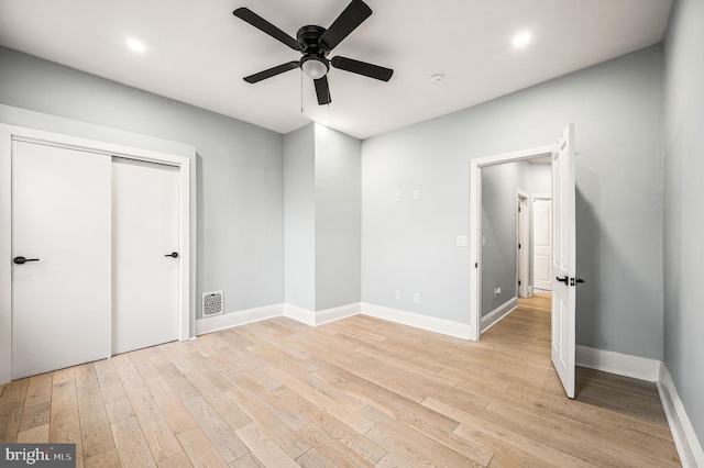 unfurnished bedroom with ceiling fan, a closet, and light hardwood / wood-style flooring