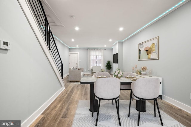 dining area with ornamental molding and wood-type flooring