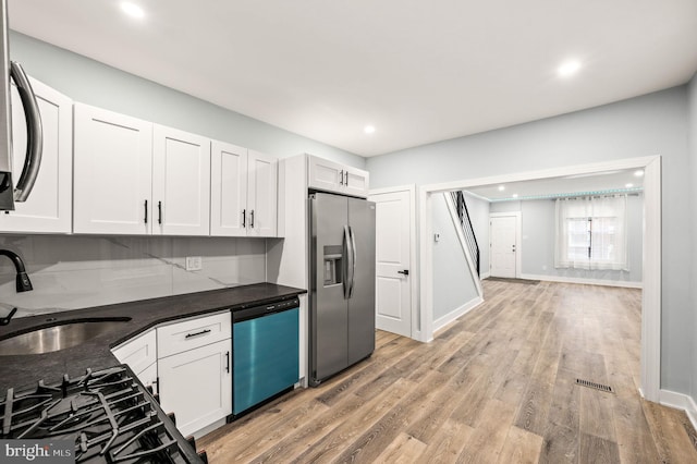 kitchen featuring sink, light hardwood / wood-style floors, white cabinets, and appliances with stainless steel finishes