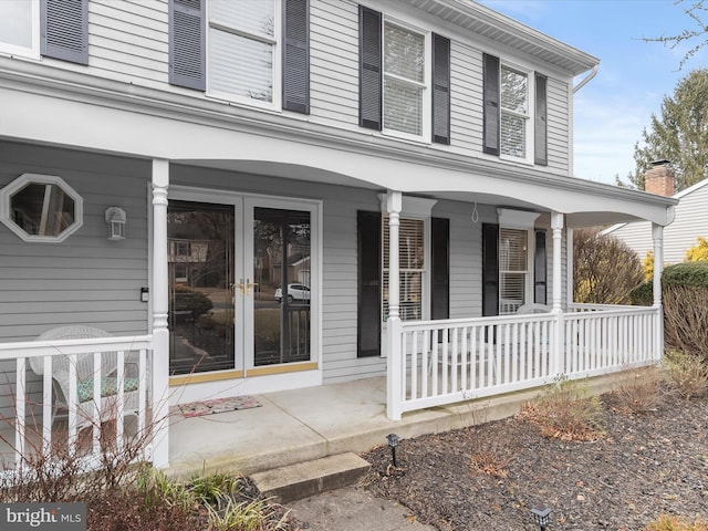 entrance to property featuring covered porch and french doors