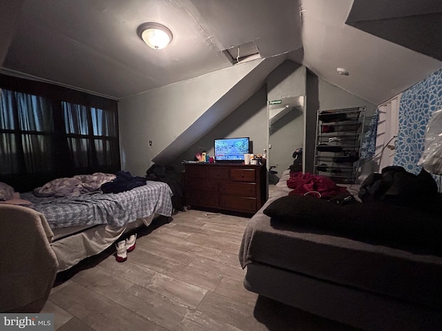 bedroom featuring lofted ceiling and light hardwood / wood-style flooring