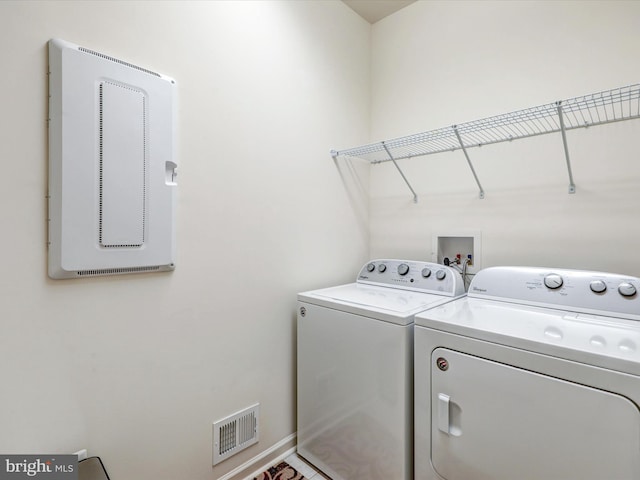 clothes washing area with laundry area, baseboards, visible vents, and washing machine and clothes dryer