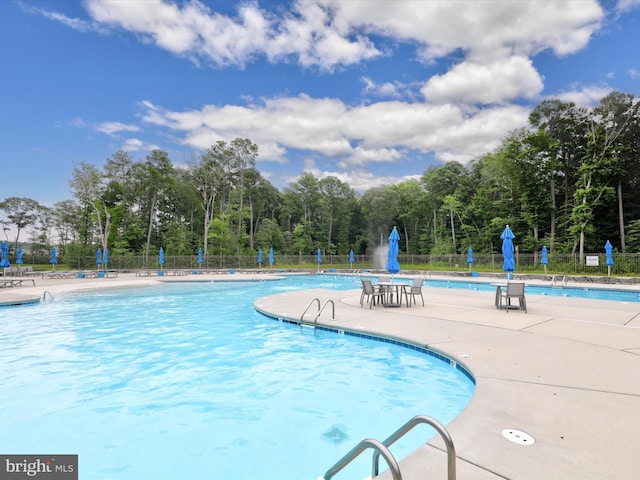 pool with a patio and fence