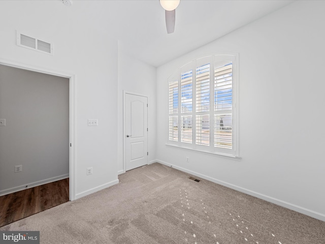 unfurnished bedroom featuring a ceiling fan, carpet, visible vents, and baseboards