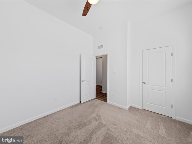 unfurnished bedroom with a ceiling fan, carpet, visible vents, and baseboards