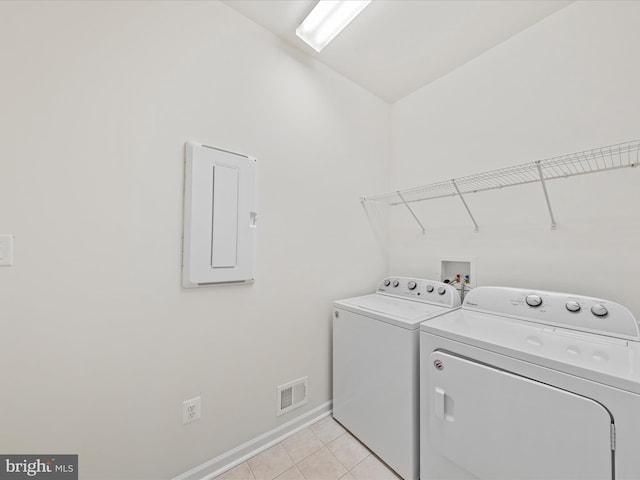 clothes washing area featuring light tile patterned flooring, laundry area, visible vents, electric panel, and washing machine and clothes dryer