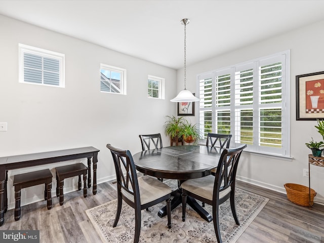 dining space with baseboards and wood finished floors