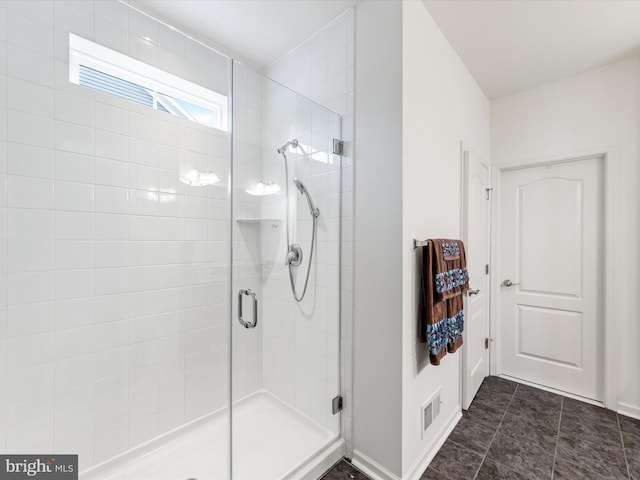 bathroom with a shower stall, visible vents, and baseboards