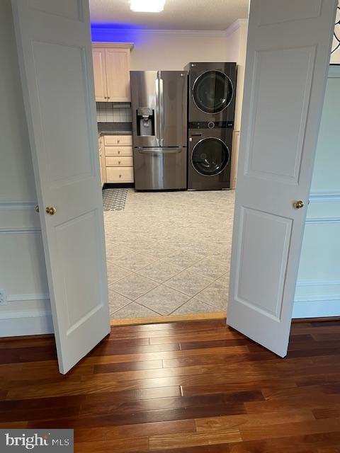 laundry area with stacked washer / dryer and dark hardwood / wood-style floors