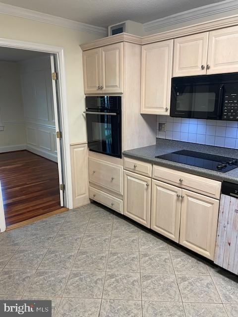 kitchen with ornamental molding, light tile patterned floors, backsplash, and black appliances