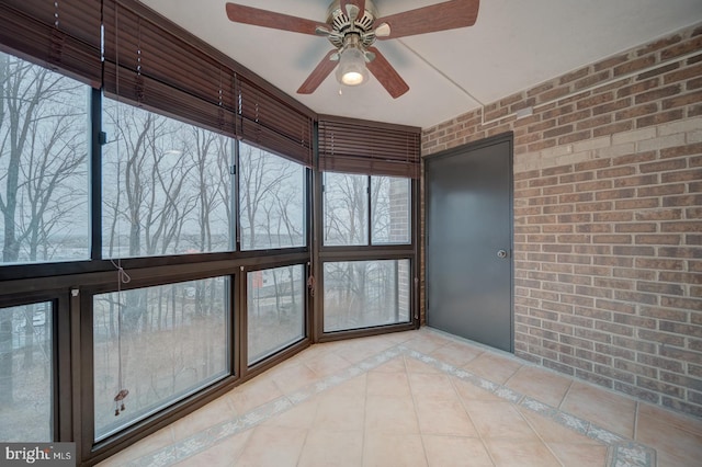 unfurnished sunroom with ceiling fan