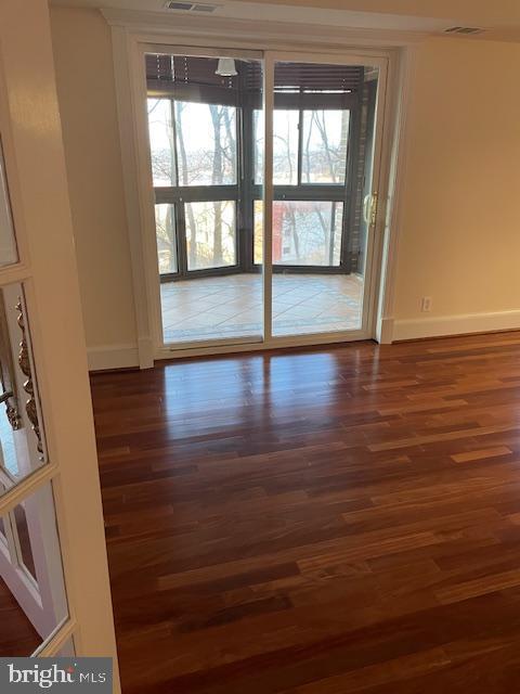 unfurnished room with dark wood-type flooring and a healthy amount of sunlight