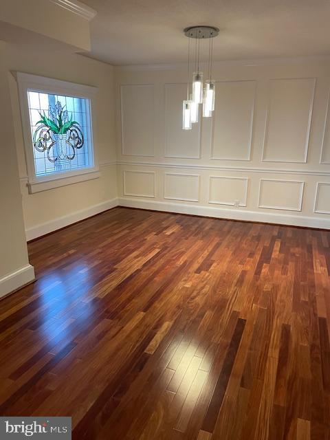 unfurnished dining area with crown molding and dark hardwood / wood-style floors