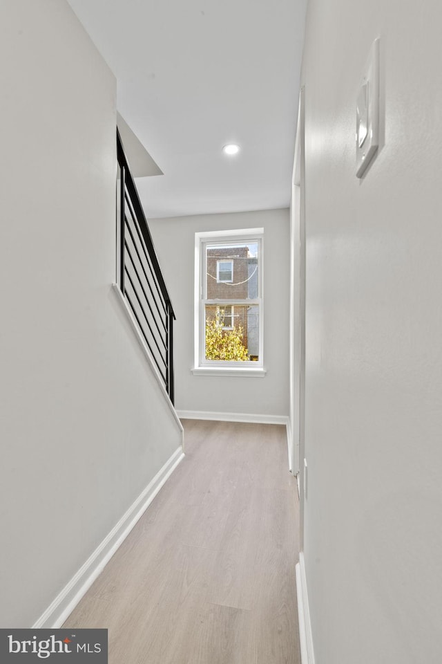 corridor with light hardwood / wood-style floors