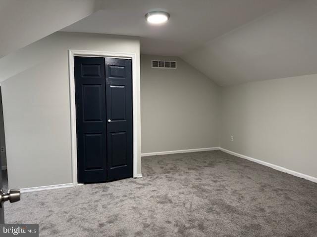 additional living space featuring vaulted ceiling and carpet floors