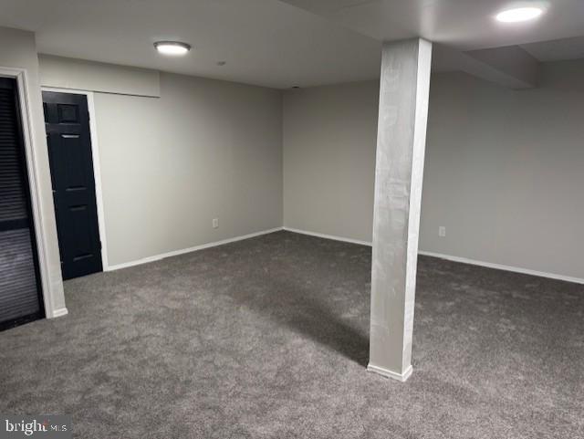 basement featuring dark colored carpet