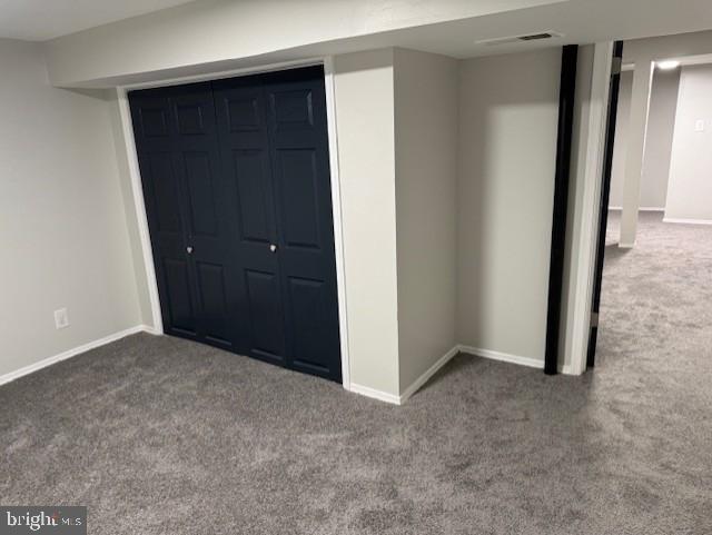 unfurnished bedroom featuring dark colored carpet and a closet